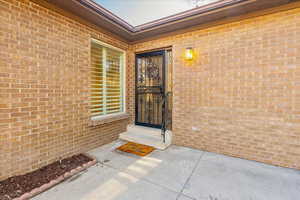 Entrance to property featuring brick siding