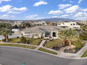 View of front facade featuring a residential view, a front yard, stone siding, and a mountain view