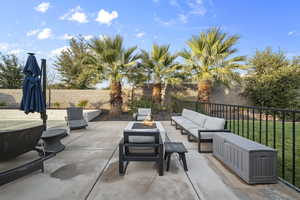 Fenced backyard featuring an outdoor living space with a fire pit and a patio