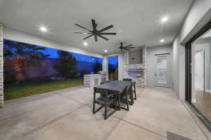 View of patio featuring exterior kitchen, outdoor dining area, and ceiling fan