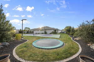 Rear view of property with a trampoline and a patio