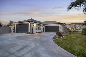 View of front of house with a garage, stucco siding, driveway, and a tiled roof