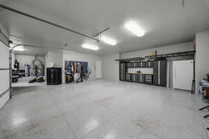 Garage with freestanding refrigerator and secured water heater