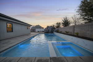 View of pool with a patio area, a fenced backyard, and a pool with connected hot tub