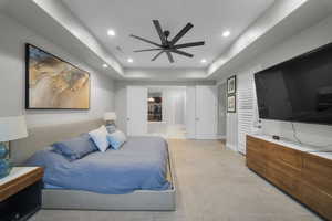 Bedroom with a tray ceiling, a ceiling fan, connected bathroom, recessed lighting, and light tile patterned floors