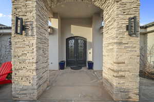 Property entrance with stucco siding, french doors, and stone siding