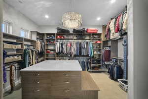Spacious closet featuring a chandelier and light tile patterned flooring