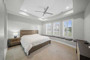 Bedroom with a raised ceiling, a ceiling fan, and recessed lighting