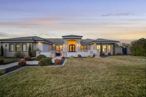 Prairie-style home featuring stone siding, a tile roof, and stucco siding