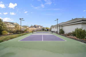 View of tennis court with a residential view