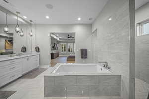 Bathroom with connected bathroom, vanity, ceiling fan, a garden tub, and recessed lighting