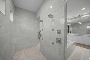 Full bathroom featuring tiled shower and vanity
