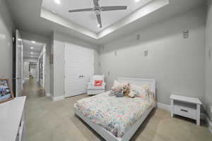 Bedroom with a tray ceiling, a closet, recessed lighting, and a ceiling fan