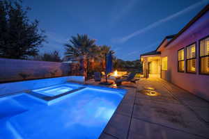 View of pool with an outdoor fire pit, a patio area, a fenced backyard, and a pool with connected hot tub