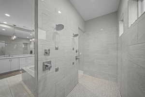 Full bathroom with vanity, tiled shower, and recessed lighting
