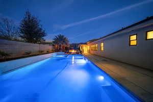 View of swimming pool featuring a fenced backyard, a patio area, and a pool with connected hot tub