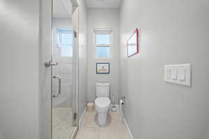 Bathroom featuring a shower stall and toilet