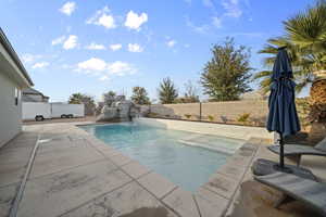 View of pool with a fenced backyard, a patio area, and a pool with connected hot tub