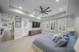 Bedroom with a tray ceiling, ceiling fan, light tile patterned floors, and recessed lighting