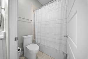 Bathroom featuring shower / bath combo with shower curtain and toilet