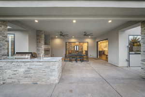 View of patio with exterior kitchen, ceiling fan, and outdoor dining space