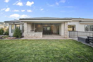 Back of property with stucco siding, ceiling fan, a patio area, and a yard