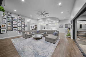Living area with a chandelier, dark wood-type flooring, and recessed lighting