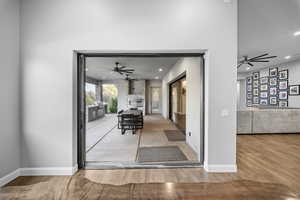 Entryway with ceiling fan, wood finished floors, and recessed lighting