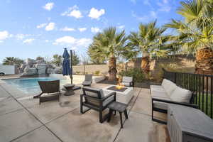 Fenced backyard with a patio and an outdoor living space with a fire pit