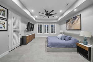 Bedroom with a tray ceiling, a ceiling fan, and recessed lighting