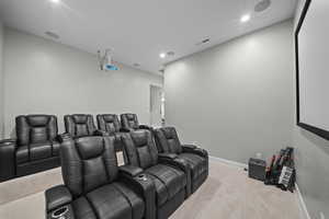 Home theater featuring light colored carpet and recessed lighting