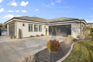 Single story home with stucco siding, a garage, a tile roof, and driveway