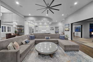 Living room with wood finished floors, a ceiling fan, and recessed lighting