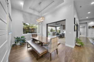 Dining area featuring recessed lighting, wood finished floors, a tray ceiling, ceiling fan, and a barn door