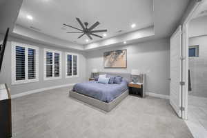 Bedroom with a tray ceiling, ceiling fan, and recessed lighting