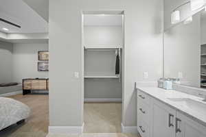 Bathroom featuring a spacious closet, vanity, and recessed lighting