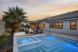 View of pool with a fenced backyard, a patio area, an outdoor fire pit, and a pool with connected hot tub