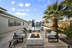 View of pool with a patio, a fire pit, and a fenced backyard