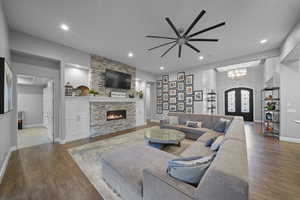 Living area featuring wood finished floors, a fireplace, a chandelier, and recessed lighting