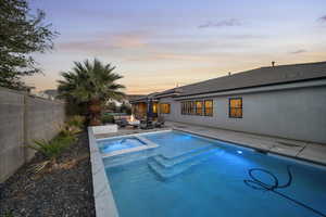 View of pool with a fenced backyard, a patio area, a pool with connected hot tub, and an outdoor living space