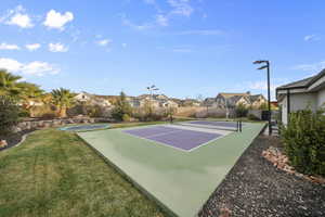 View of tennis court with a residential view