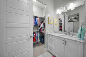 Bathroom with vanity and a spacious closet