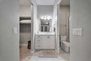 Bathroom with vanity and a walk in closet