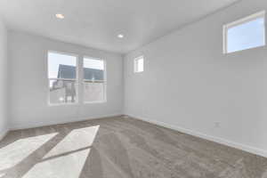 Empty room with carpet and recessed lighting