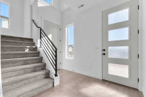 Foyer entrance with light wood-type flooring and a high ceiling