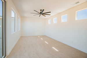 Empty room featuring light carpet and ceiling fan