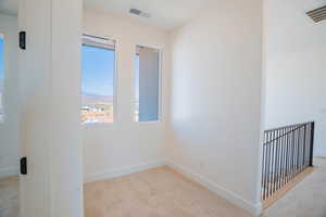 Unfurnished room featuring light colored carpet