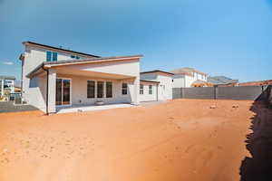 Back of house with a patio area, a fenced backyard, and stucco siding
