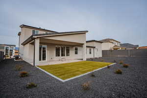 Rear view of property with a patio area, a fenced backyard, and stucco siding
