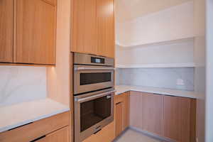 Kitchen featuring double oven, light brown cabinets, and modern cabinets